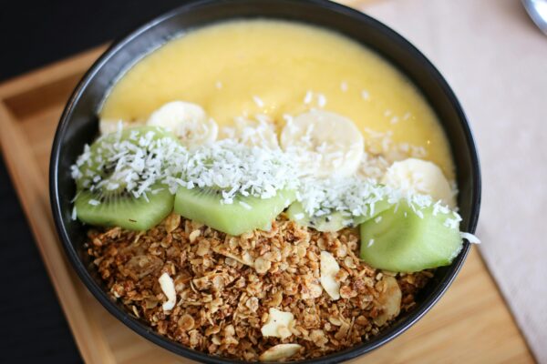 Delicious and nutritious breakfast bowl with kiwi, banana, coconut, and granola.